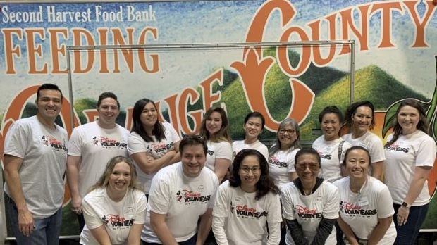 Disney volunteers in front of food bank backdrop